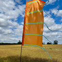 Festival flag set up on grass using ground spike base