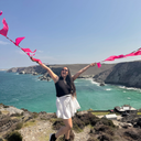 Person holding pink bunting with a scenic ocean view in the background